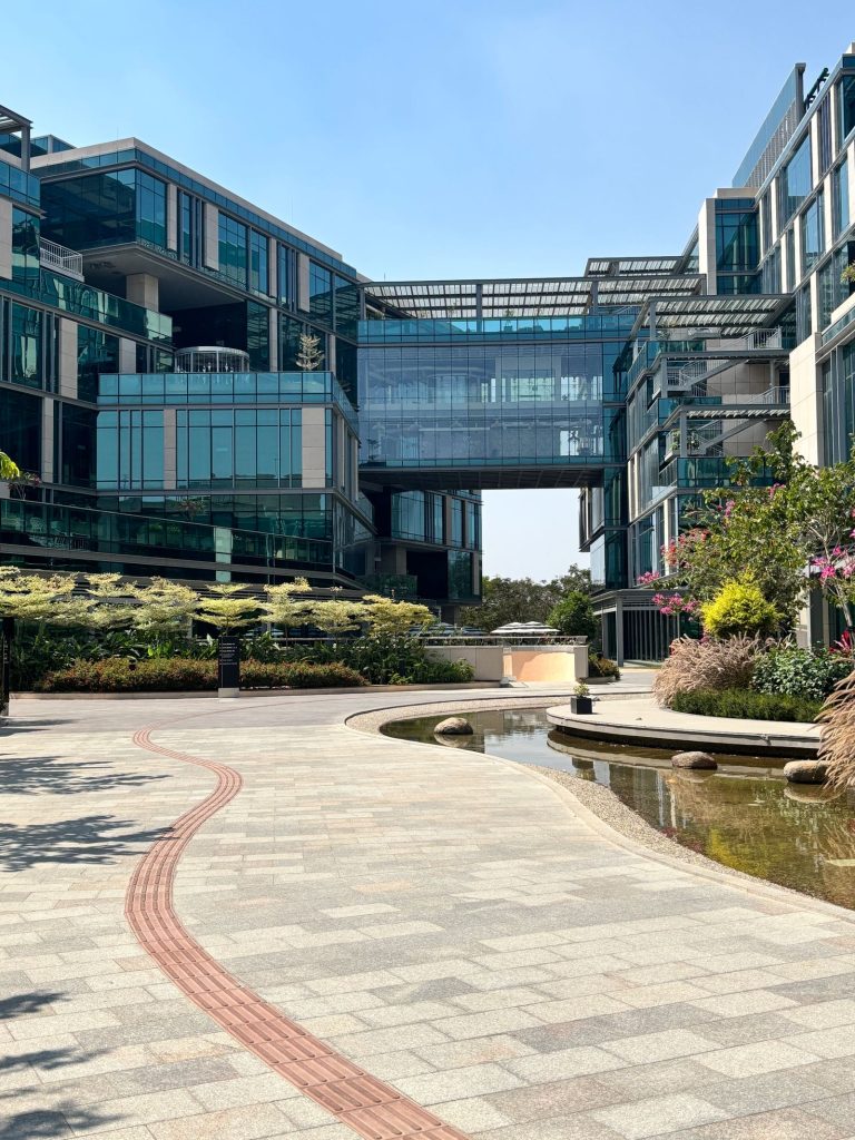 Landscaped corporate tech-park campus with paved plaza, planting and water feature