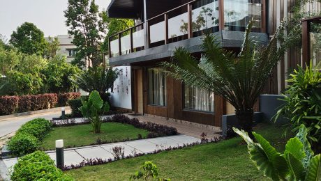 Modern Indian home with a landscaped garden, lawn, clipped hedges and tropical planting