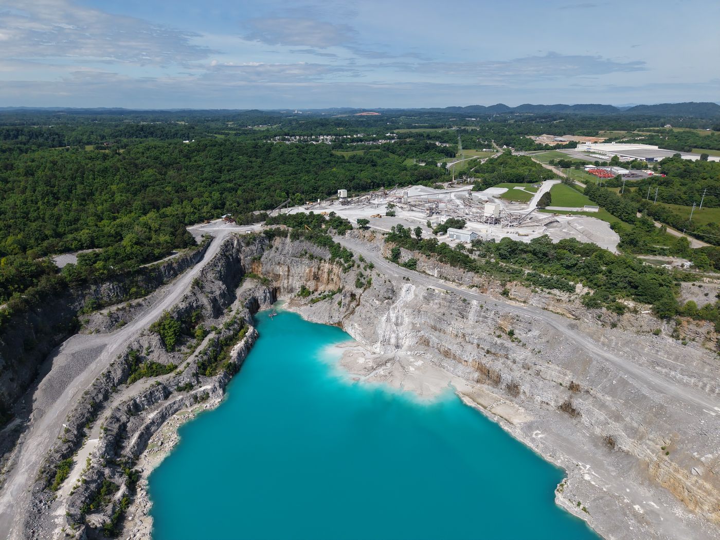 An open-cast quarry — the kind of disturbed ground a cement-plant green belt must reclaim.